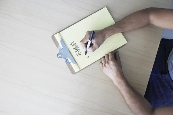 Man writing on clipboard — Stock Photo, Image