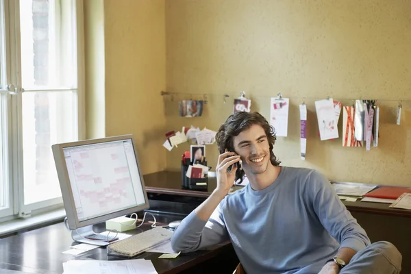 Mann telefoniert am Schreibtisch — Stockfoto