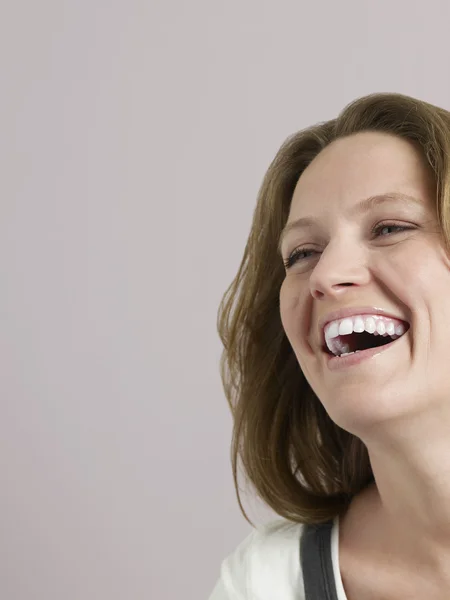 Vrouw lachend in studio — Stockfoto