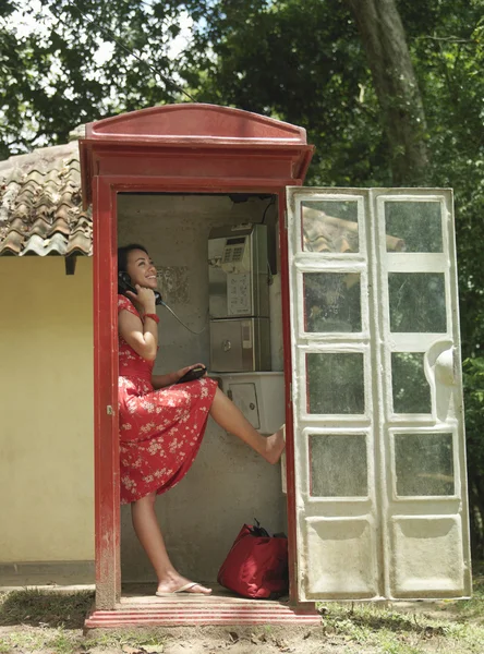 Молодая женщина в телефонной будке — стоковое фото