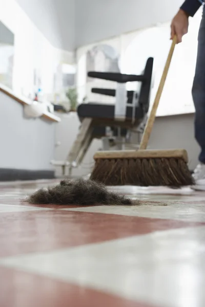 Barber sweeping floor — Stock Photo, Image