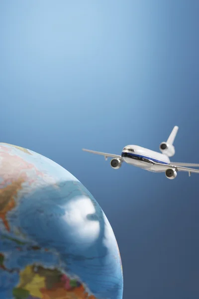 Aeroplane toy next to globe — Stock Photo, Image