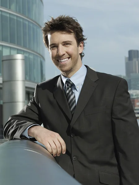 Businessman leaning on pipe — Stock Photo, Image