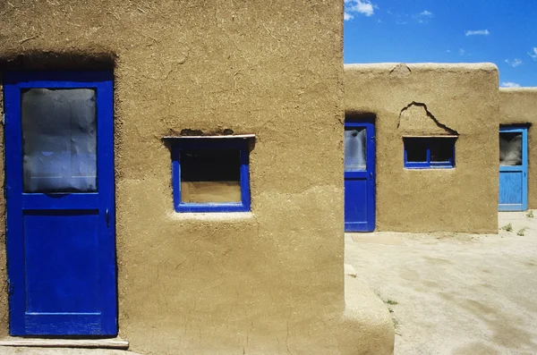 Adobe huizen met blauwe windows — Stockfoto