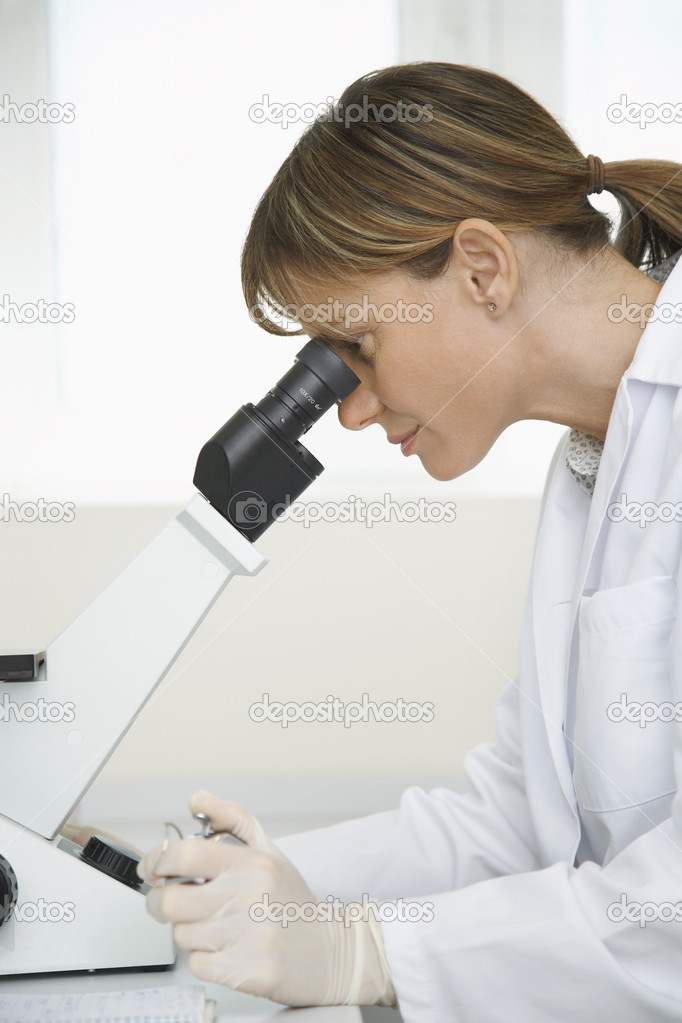 female Technician Using Microscope