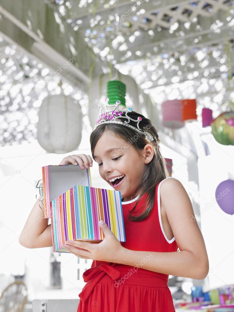 Girl opening birthday present ⬇ Stock Photo, Image by © londondeposit #33861913