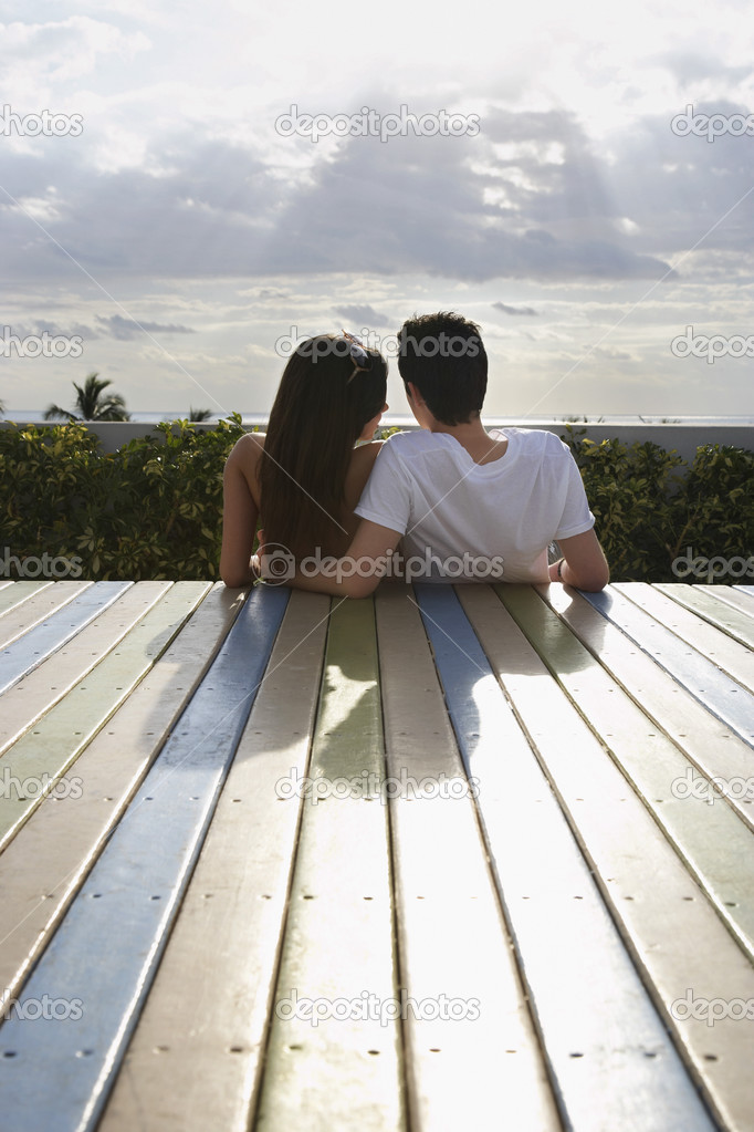 Teenage couple sitting on deck