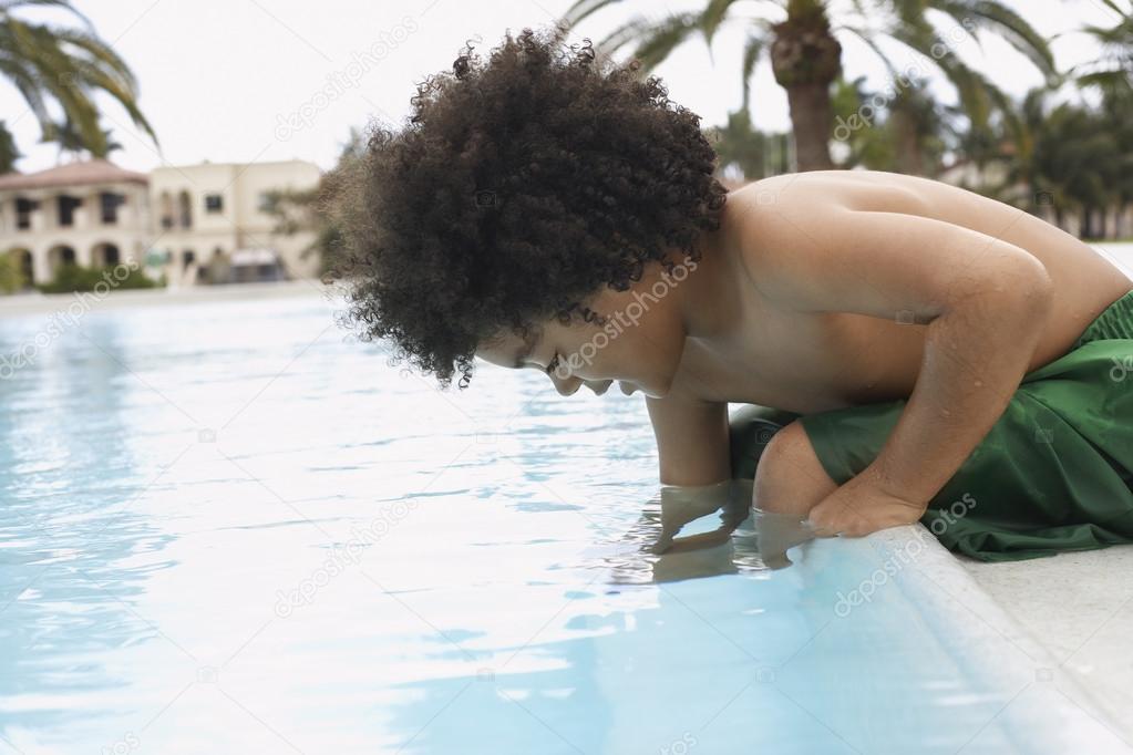 black Boy  sitting on pool 
