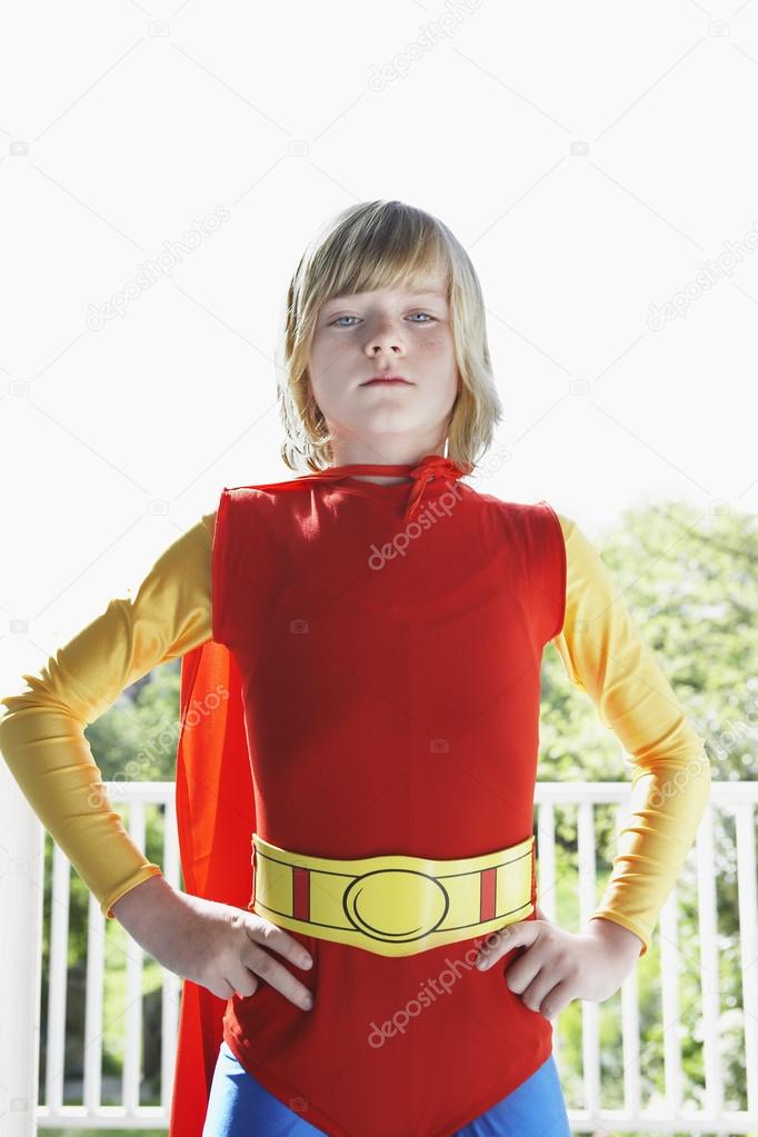 Boy in superhero costume with hands on hip