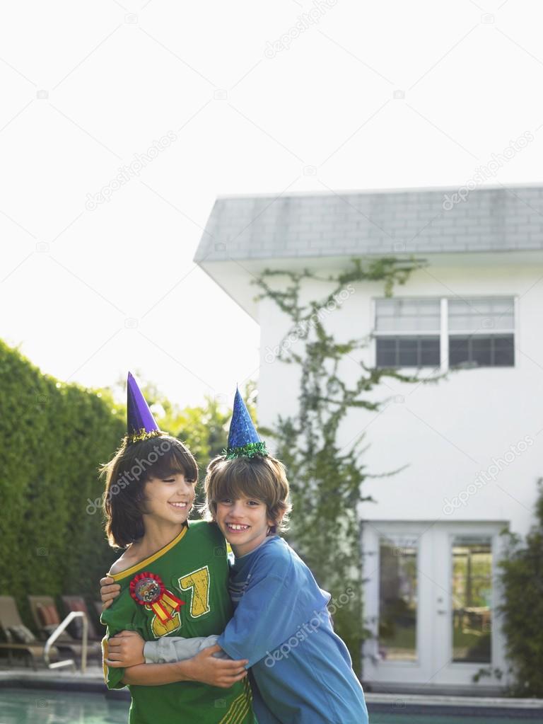 Two boys  in party hats 