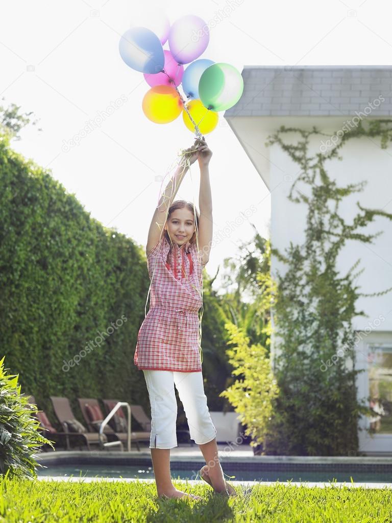 Girl holding balloons over head