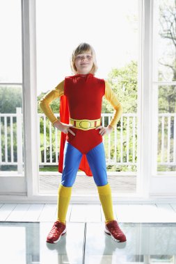 Boy in superhero costume with hands on hip clipart