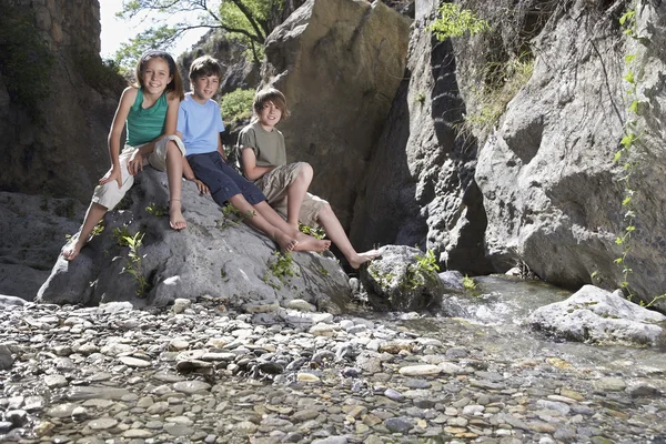 Kinderen zitten op rots — Stockfoto