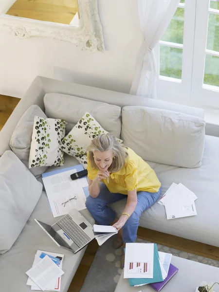 Kvinna som använder laptop på soffan — Stockfoto