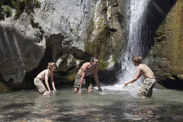 Far och söner i naturlig Pool — Stockfoto