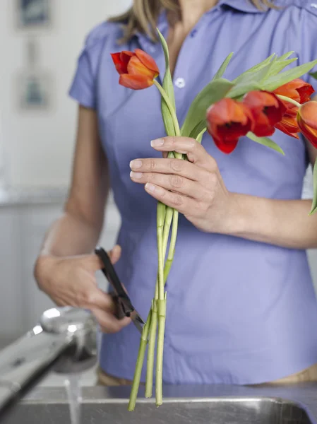 Femme rinçant et coupant des fleurs — Photo