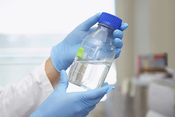 Chemist holding bottle of solution — Stock Photo, Image