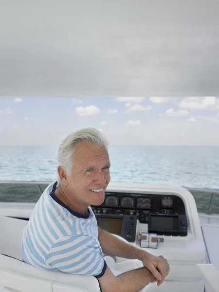 Man sitting at helm of yacht — Stock Photo, Image