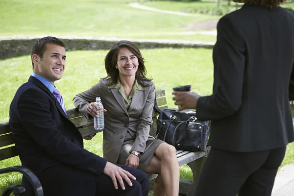 Homme d'affaires et femme assis sur le banc du parc — Photo