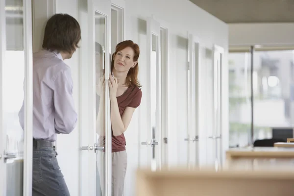 Colleagues talking through office doors — Stock Photo, Image