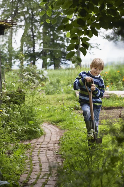 Chlapec zahradnictví s rýčem — Stock fotografie