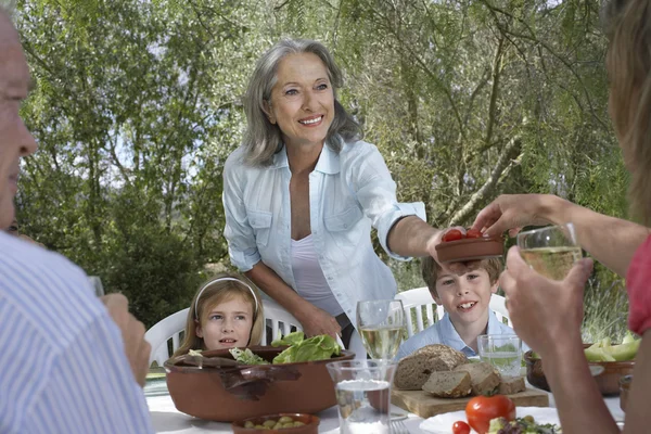 Familjen äter på trädgårdsbord — Stockfoto