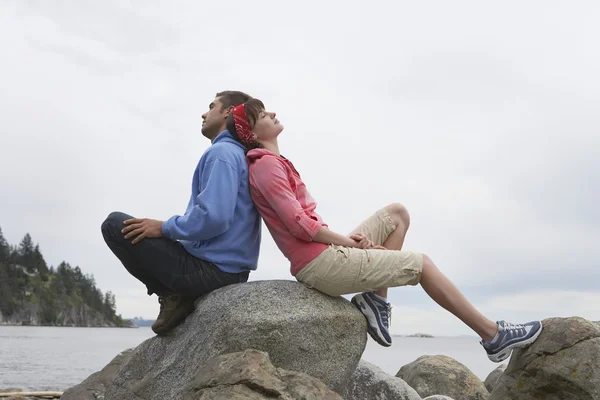 Couple sitting back to back — Stock Photo, Image