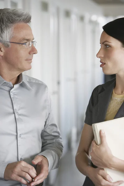 Zakenman en vrouwelijke collega praten in office — Stockfoto