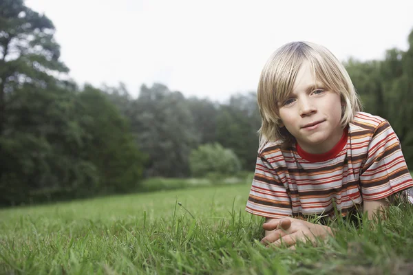 Pojken låg i äng — Stockfoto