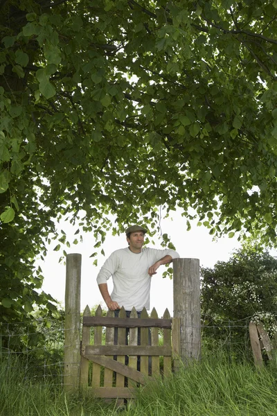 Agricultor em pé no portão — Fotografia de Stock