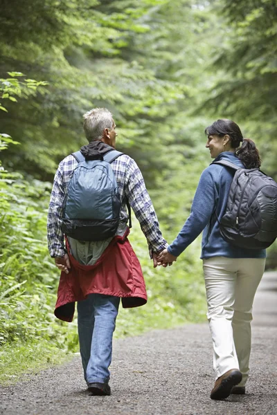 Couple walking along forest road — Stock Photo, Image