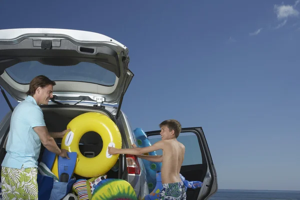 Padre e hijo descargando coche —  Fotos de Stock