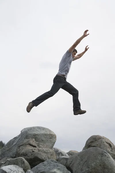 Mann springt mit erhobenen Armen — Stockfoto