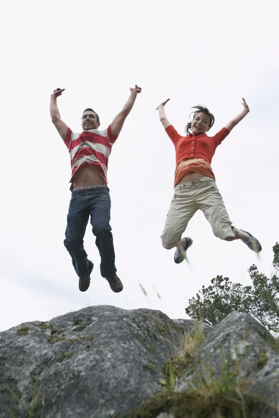 Couple bondissant avec les bras levés — Photo