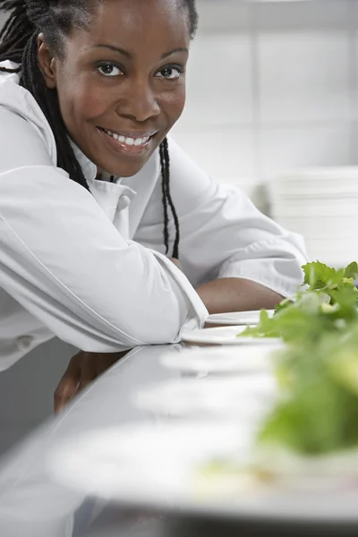 Kock med plattor av sallad leende — Stockfoto