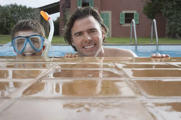 Lachende vader en zoon in zwembad — Stockfoto
