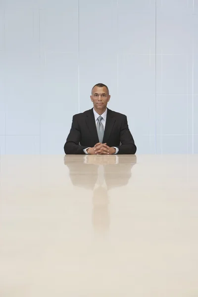 Geschäftsmann sitzt am Ende des Konferenztisches — Stockfoto