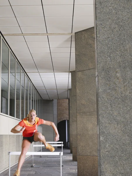 Atleta saltando sobre obstáculos — Fotografia de Stock