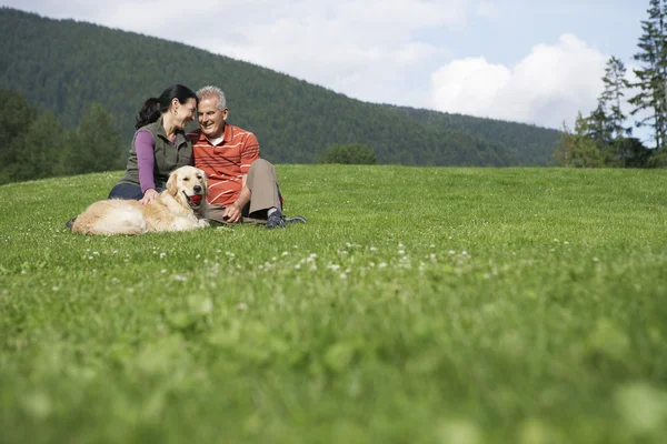 Couple assis dans la prairie — Photo