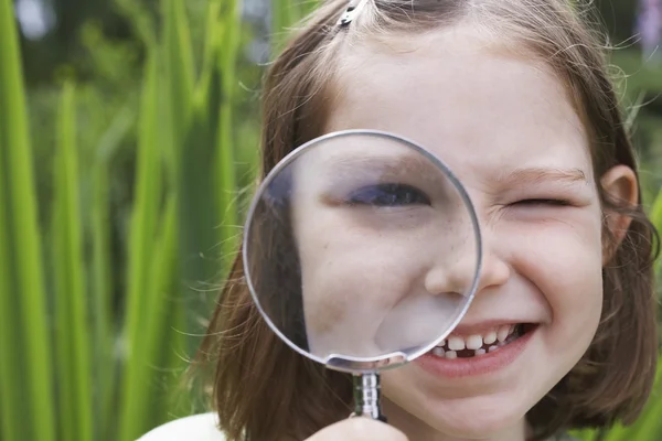 Fille regardant à travers la loupe — Photo