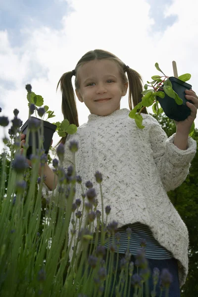 Kız holding bitkiler — Stok fotoğraf
