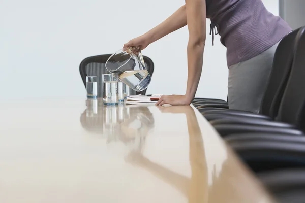 Trabajador de oficina vertiendo agua en vasos — Foto de Stock