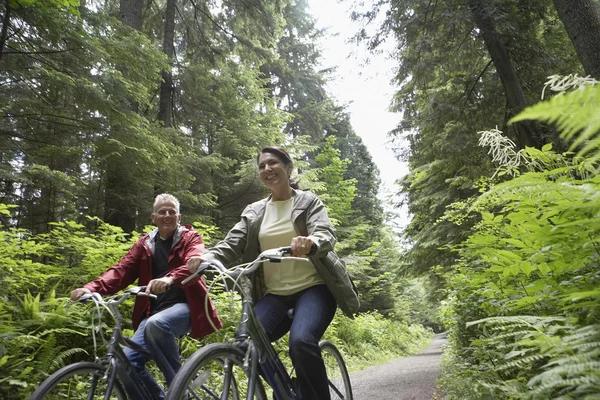 Man and middle-aged woman riding bicycles — Stock Photo, Image