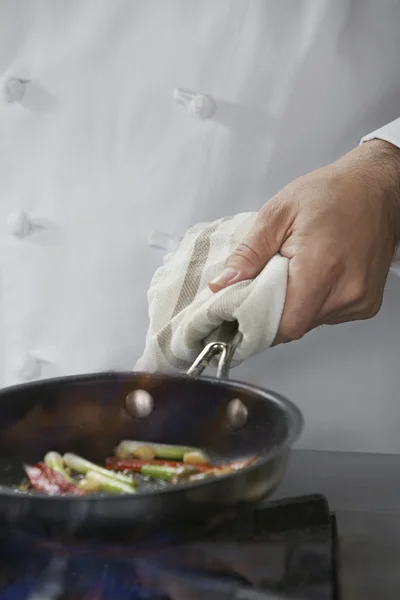 Chef cooking food in frying pan — Stock Photo, Image