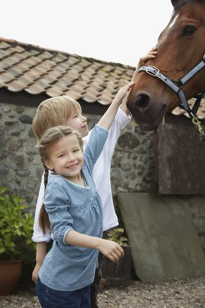 Kinder streicheln Pferd — Stockfoto