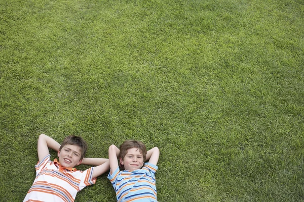 Meninos deitados na grama — Fotografia de Stock