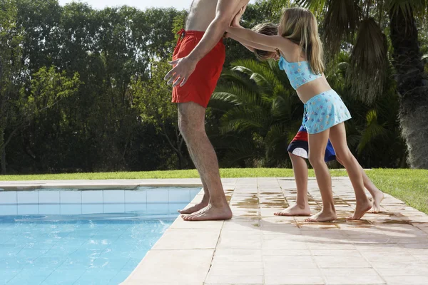 Bambini che spingono padre — Foto Stock