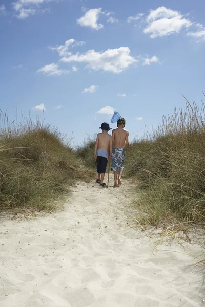 Boys walking in sand dunes — Stock Photo, Image