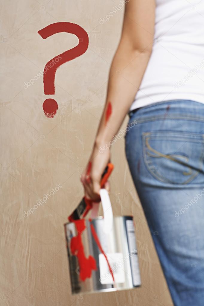 Woman holding painting can and question mark