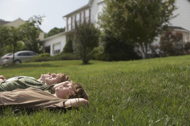 Genç kardeşler çimlere uzanmış